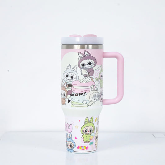 A pastel-colored tumbler featuring Labubu characters dressed in bunny costumes, surrounded by macarons and candy graphics, with a pink handle and white background.